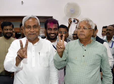 Nitish Kumar (L), a leader of Janata Dal (United) and Chief Minister of Bihar, and Lalu Prasad Yadav, chief of Rashtriya Janata Dal, gesture after addressing a news conference in Patna, November 8, 2015. REUTERS/Stringer