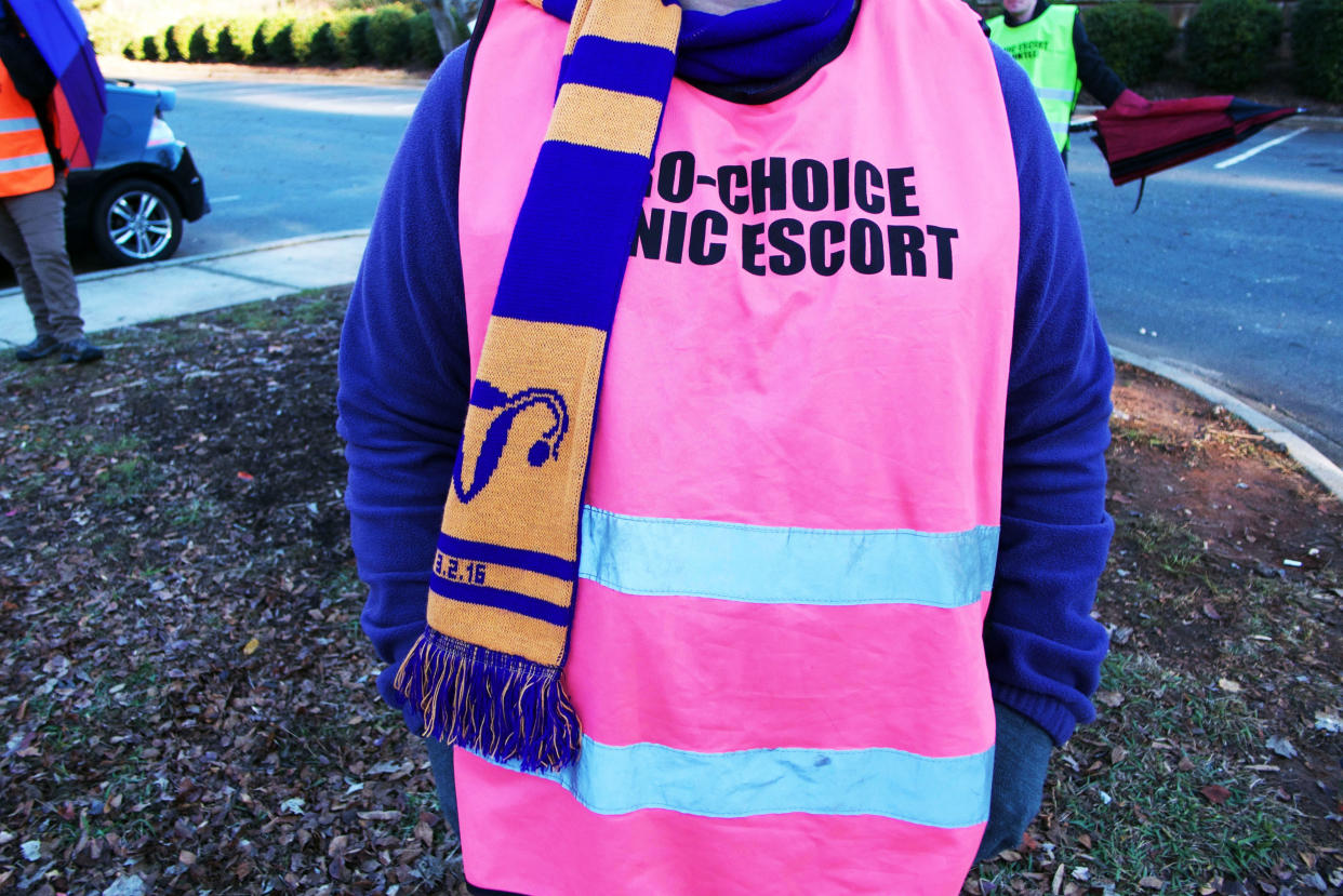 A volunteer clinic escort stands in the parking lot of A Preferred Women's Health Center on Saturday morning in Charlotte, North Carolina.&nbsp;