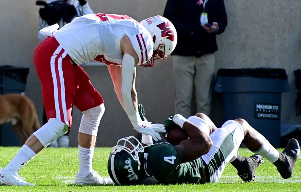 Michigan State Spartans linebacker Jacoby Windmon (4) intercepts a pass intended for Wisconsin Badgers tight end Jack Eschenbach (82) in the first quarter on Saturday, Oct. 15, 2022, at Spartan Stadium.