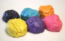 Sugar cookie dough is divided and mixed with food coloring to achieve the desired result.