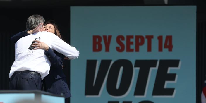 Vice President Kamala Harris and Gov. Gavin Newsom embrace on stage during an anti-recall rally in September 2021.