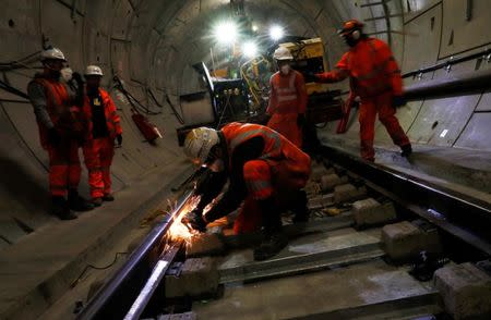 FILE PHOTO: Workers lay railway track in a tunnel of the Crossrail project in Stepney, east London, Britain, November 16, 2016. REUTERS/Stefan Wermuth