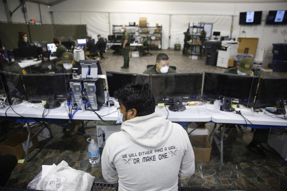 FILE - In this March 30, 2021, file photo, an unidentified migrant is processed at the intake area of the U.S. Customs and Border Protection facility, the main detention center for unaccompanied children in the Rio Grande Valley, in Donna, Texas. Migrant families will be held at hotels in the Phoenix area in response to a growing number of people crossing the U.S.-Mexico border, authorities said Friday, April 9, 2021 another step in the Biden administration's rush to set up temporary space for them. (AP Photo/Dario Lopez-Mills,Pool, File)