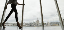 A model walks past a window with a view of St Paul's Cathedral during the presentation of the Matthew Williamson Spring/Summer 2013 collection at London Fashion Week, Sunday, Sept. 16, 2012. (AP Photo/Alastair Grant)
