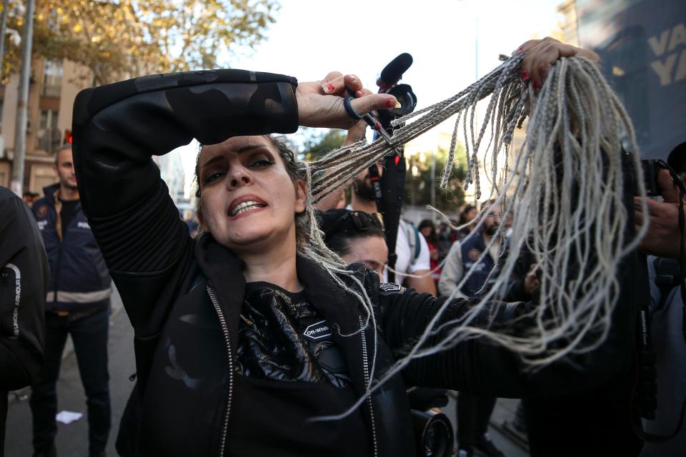 An Iranian woman cuts her hair during a demonstration outside the Iranian Consulate in Istanbul, Turkey, on Oct. 22, 2022.