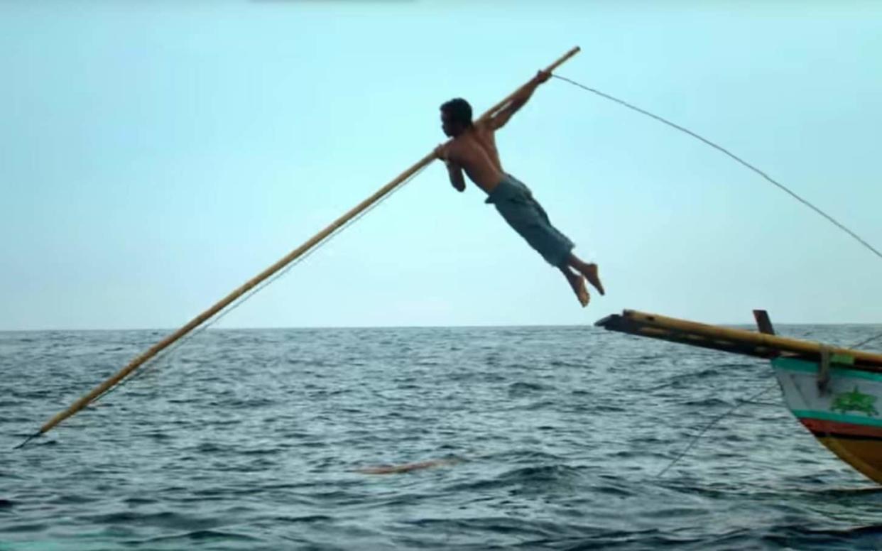 Benjamin is show leaping from the boat with a harpoon - BBC