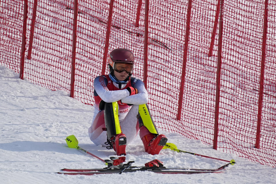 Mikaela Shiffrin, of the United States sits on the side of the course after skiing out in the first run of the women's slalom at the 2022 Winter Olympics, Wednesday, Feb. 9, 2022, in the Yanqing district of Beijing. (AP Photo/Robert F. Bukaty)