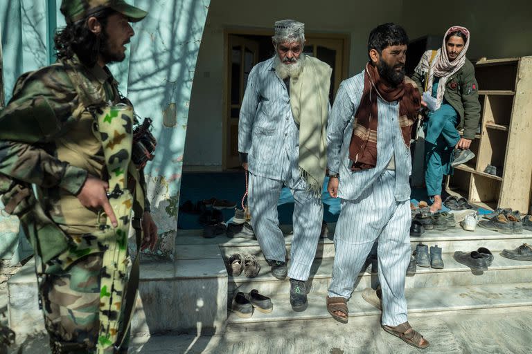 Los guardias de seguridad talibanes escoltan a un hombre afgano (centro a la izquierda), que ha sido condenado a muerte por asesinato, y a otro prisionero después de una audiencia en el Tribunal de Apelaciones de Ghazni