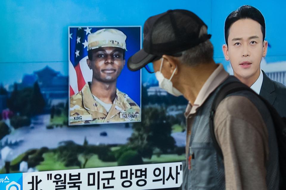 In this photo taken in Seoul on August 16, 2023, a man walks past a television showing a news broadcast featuring a photo of US soldier Travis King (C), who ran across the border into North Korea while part of a tour group visiting the Demilitarized Zone on South Korea's border on July 18. North Korea has decided to expel US soldier Travis King, who was detained after crossing the border from the South in July, the KCNA state news agency said on September 27.