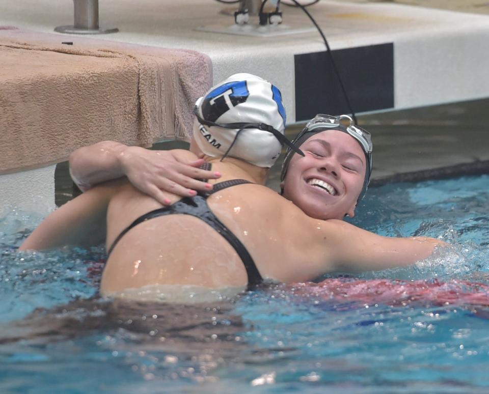 Fossil Ridge High School swimmer Lucy Bell is all smiles while exchanging a celebratory hug with Julia Matney after winning the 100-yard butterfly in March 2021 during the Colorado 5A state championships at Veterans Memorial Aquatic Complex in Thornton.