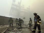 <p>With the skeleton of the World Trade Center twin towers in the background, New York City firefighters work amid debris on Cortlandt Street after the terrorist attacks on Sept. 11, 2001. (Photo: Mark Lennihan/AP) </p>