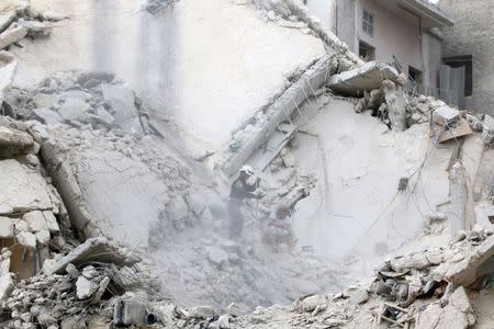 People inspect a damaged site after airstrikes on the rebel held al-Qaterji neighbourhood of Aleppo, Syria September 23, 2016. REUTERS/Abdalrhman Ismail