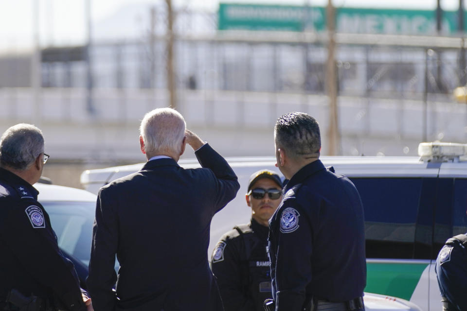 President Joe Biden, second from left, looks towards a large "Welcome to Mexico" sign that is hung over the Bridge of the Americas as he tours the El Paso port of entry, a busy port of entry along the U.S.-Mexico border, in El Paso Texas, Sunday, Jan. 8, 2023. (AP Photo/Andrew Harnik)