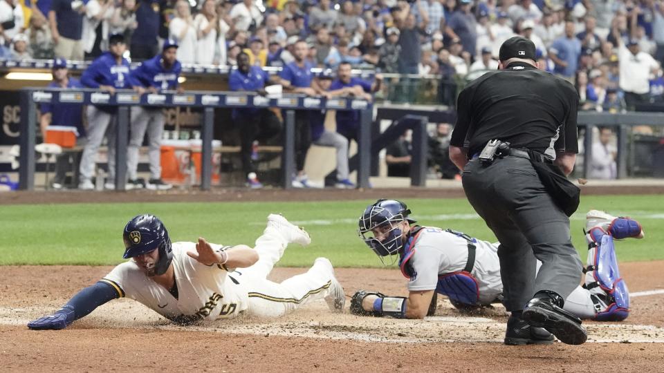 Milwaukee Brewers' Tyrone Taylor slides safely past Los Angeles Dodgers catcher Austin Barnes during the eighth inning of a baseball game Wednesday, Aug. 17, 2022, in Milwaukee. Taylor scored on a hit by Christian Yelich. (AP Photo/Morry Gash)