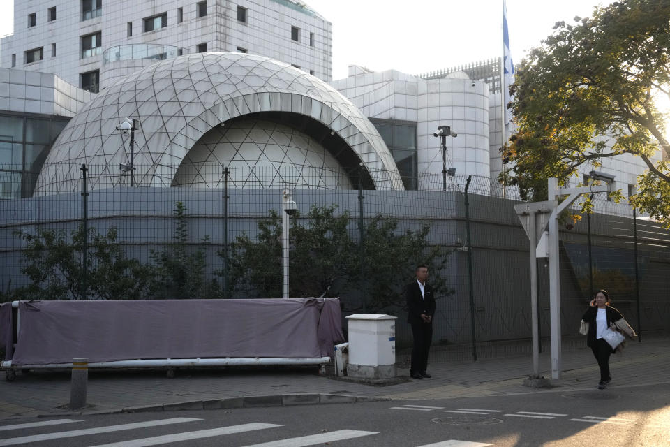 A plainclothes security person stands watch outside the Israeli Embassy in Beijing, Friday, Oct. 13, 2023. An employee of the Israeli Embassy in Beijing has been attacked and was later hospitalized, according to a statement from Israel's Foreign Ministry on Friday. (AP Photo/Ng Han Guan)