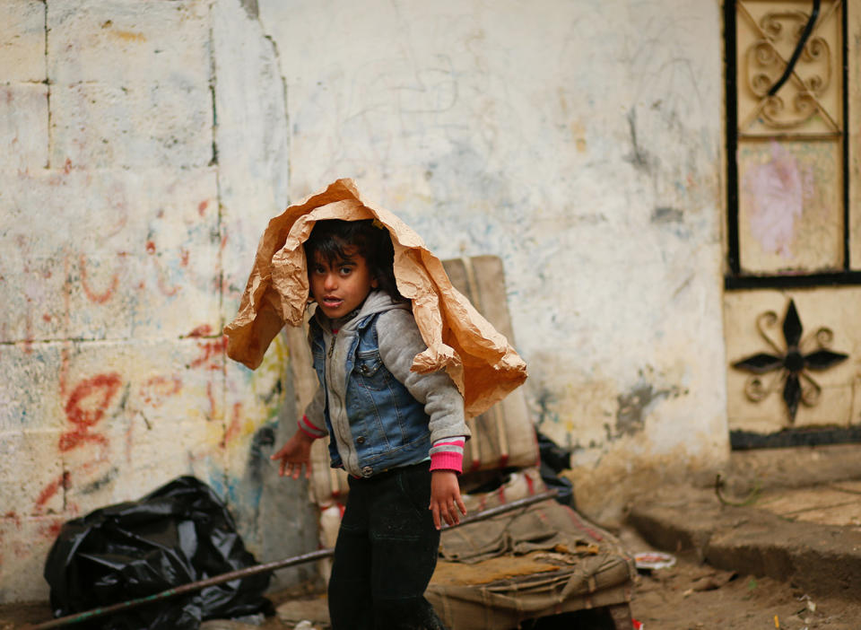 Palestinian girl walks outside her house in Gaza Strip