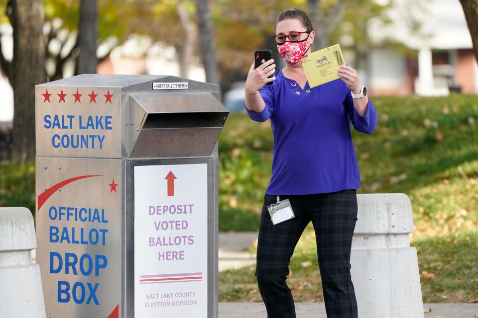 Jennifer Fresques takes a selfie before inserting her ballot into an official ballot drop box Tuesday, Oct. 20, 2020, in Salt Lake City.