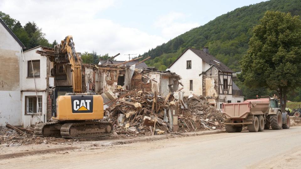 Ein Bagger reisst in Altenburg (Rheinland-Pfalz) Häuser ab, die durch die Flutkatastrophe zerstört wurden.