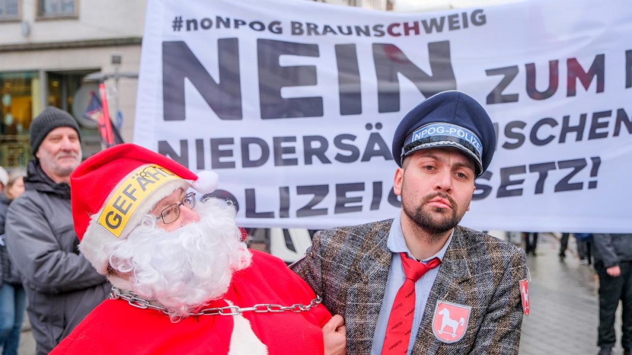 Als Weihnachtsmann und Polizist verkleidet protestieren Teilnehmer des Demonstrationszug gegen das geplante niedersächsische Polizeigesetz. Foto: Clemens Heidrich