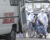 Health workers attend patient at jumbo Covid-19 centre in Mumbai, India, Thursday, April 22, 2021. A fire killed 13 COVID-19 patients in a hospital in western India early Friday as an extreme surge in coronavirus infections leaves the nation short of medical care and oxygen. India reported another global record in daily infections for a second straight day Friday, adding 332,730 new cases. The surge already has driven its fragile health systems to the breaking point with understaffed hospitals overflowing with patients and critically short of supplies. (AP Photo/Rafiq Maqbool)