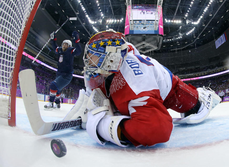 USA forward Phil Kessel reacts as Russia goaltender Sergei Bobrovski can't stop a goal by USA defenseman Cam Fowler during the second period of a men's ice hockey game at the 2014 Winter Olympics, Saturday, Feb. 15, 2014, in Sochi, Russia. (AP Photo/Bruce Bennett, Pool)