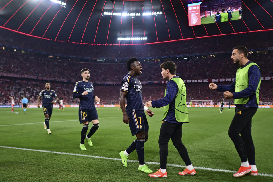 Real Madrid's Vinicius Junior, centre, celebrates with his teammates after scoring his side's second goal on a penalty kick during the Champions League semifinal first leg soccer match between Bayern Munich and Real Madrid at the Allianz Arena in Munich, Germany, Tuesday, April 30, 2024. (AP Photo/Christian Bruna)