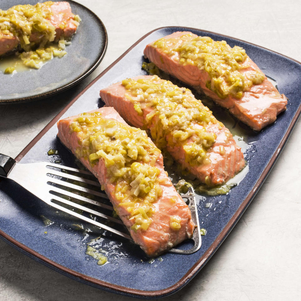 This undated photo provided by America's Test Kitchen in May 2019 shows Salmon with Leeks and White Wine in Brookline, Mass. This recipe appears in the cookbook “How to Braise Everything.” (Carl Tremblay/America's Test Kitchen via AP)