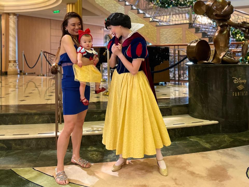 Tiffany Leigh and her baby, dressed as snow white, posing for a photo with a woman wearing a Snow White costume on Disney Fantasy cruise