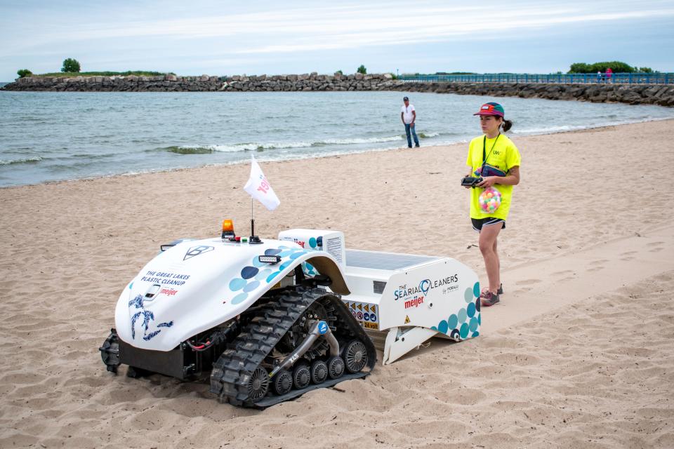 Amanda Hoehn, a research student at the University of Wisconsin-Oshkosh, operates a BeBot on July 12 in the Manitowoc Marina. The Bebot is an electric, remote-controlled robot that combs through the sand along beaches, collecting things like plastic litter, bottle caps, cans, cigarettes and food wrappers.