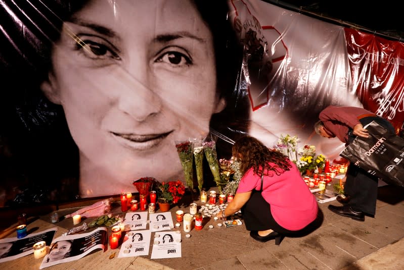 FILE PHOTO: People lay flowers and candles at a makeshift memorial during a vigil and protest on the first anniversary of the assassination of anti-corruption journalist Daphne Caruana Galizia in a car bomb, outside the Courts of Justice in Valletta