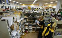 Sabine Standke, 32-year-old postwoman of the German postal and logistics group Deutsche Post, sorts mail at a sorting office in Berlin's Mitte district, December 4, 2013. Deutsche Post, the world's number one postal and logistics group transported around 18 billion letters in 2012. REUTERS/Fabrizio Bensch (GERMANY - Tags: BUSINESS EMPLOYMENT)