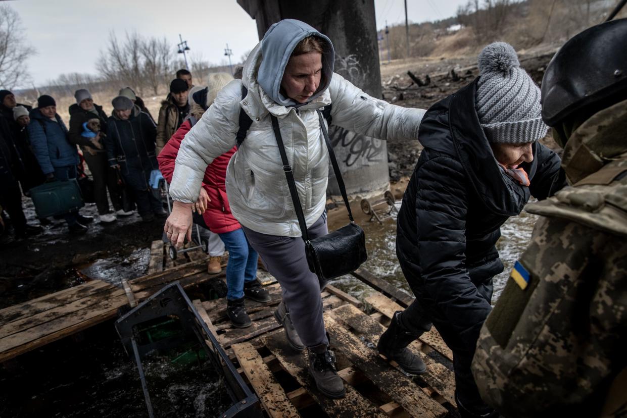 Residents of Irpin flee heavy fighting via a destroyed bridge as Russian forces entered the city on March 07, 2022, in Irpin, Ukraine. Yesterday, four civilians were killed by mortar fire along the road leading from Irpin to Kyiv, which has been a key evacuation route for people fleeing Russian forces advancing from the north. Today, Ukraine rejected as "unacceptable" a Russian proposal for a humanitarian corridor that leads from Kyiv to Belarus, a Russian ally that was a staging ground for the invasion.