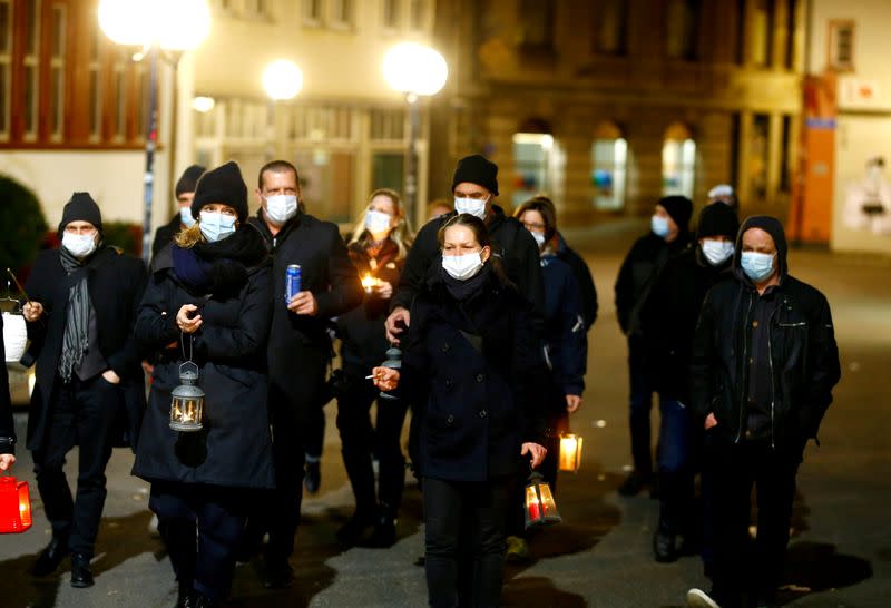 A pesar de las grandes reuniones, como la tradicional Morgenstreich, que fue cancelada por el gobierno suizo para evitar la propagación del coronavirus, un grupo de revitalizadores de carnaval que llevan máscaras de protección marchan a través del casco antiguo de Basilea, Suiza