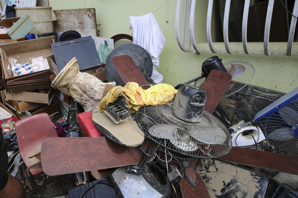 Juan Medina-Dishmey and his wife, Juana Ferrera, cleared out damaged belongings from their home in Valle Hill, Can&oacute;vanas, Puerto Rico. They told HuffPost they feared it may all be contaminated with the leptospirosis bacteria. (Photo: Carolina Moreno/HuffPost)