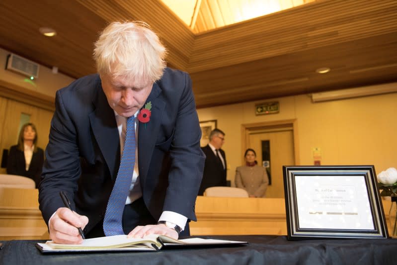 Britain's Prime Minister Boris Johnson signs a book of condolence during a visit to Thurrock Council Offices in Grays