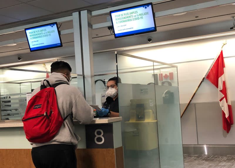 A Canada Border Services Agency (CBSA) officer wears a protective face mask in Toronto