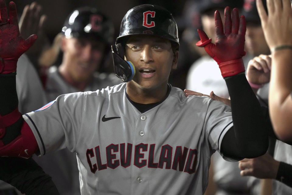 Cleveland Guardians' Bo Naylor is congratulated in the dugout after hitting a home run that also scored teammate Myles Straw during the third inning of a baseball game against the Texas Rangers in Arlington, Texas, Friday, July 14, 2023. (AP Photo/LM Otero)