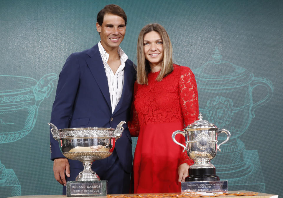 Defending champions Spain's Rafael Nadal, left, and Romania's Simona Halep pose next to the cups during the draw of the French Open tennis tournament at the Roland Garros stadium in Paris, Thursday, May 23, 2019. The French Open tennis tournament starts Sunday May 26. (AP Photo/Michel Euler)