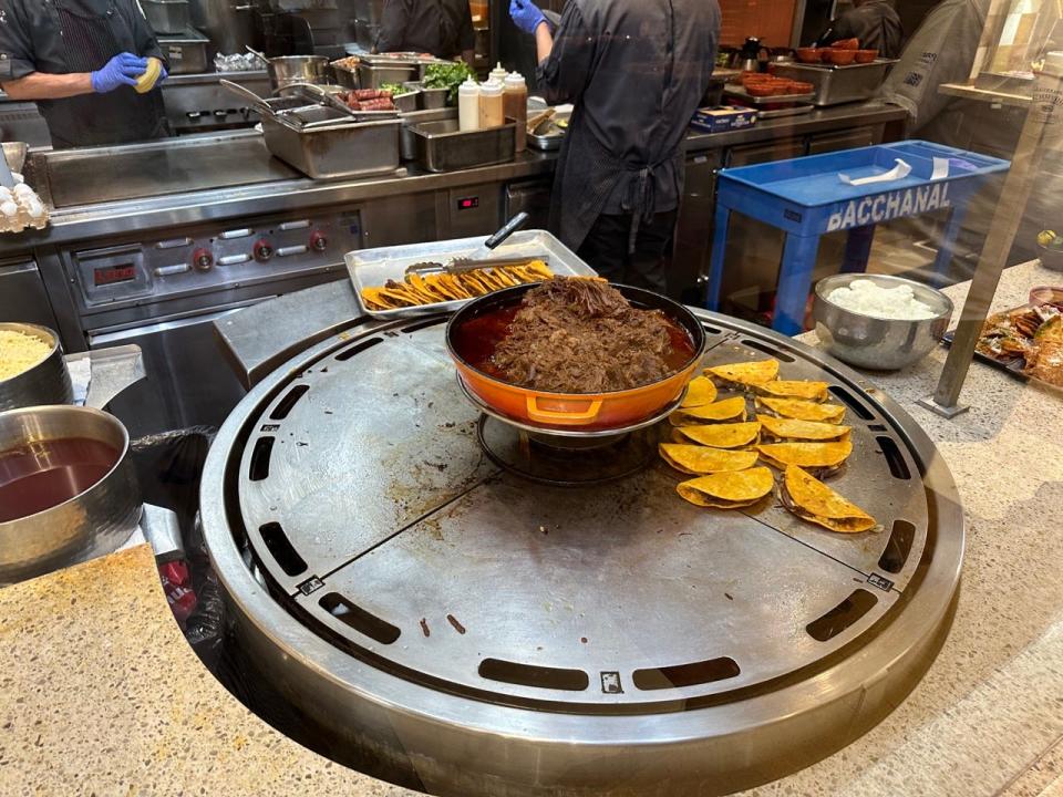 Pot of shredded meat with tacos around it at Bacchanal buffet