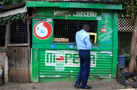 A customer conducts a mobile money transfer, known as M-Pesa, at a Safaricom agent stall in Nairobi, Kenya October 16, 2018. REUTERS/Thomas Mukoya