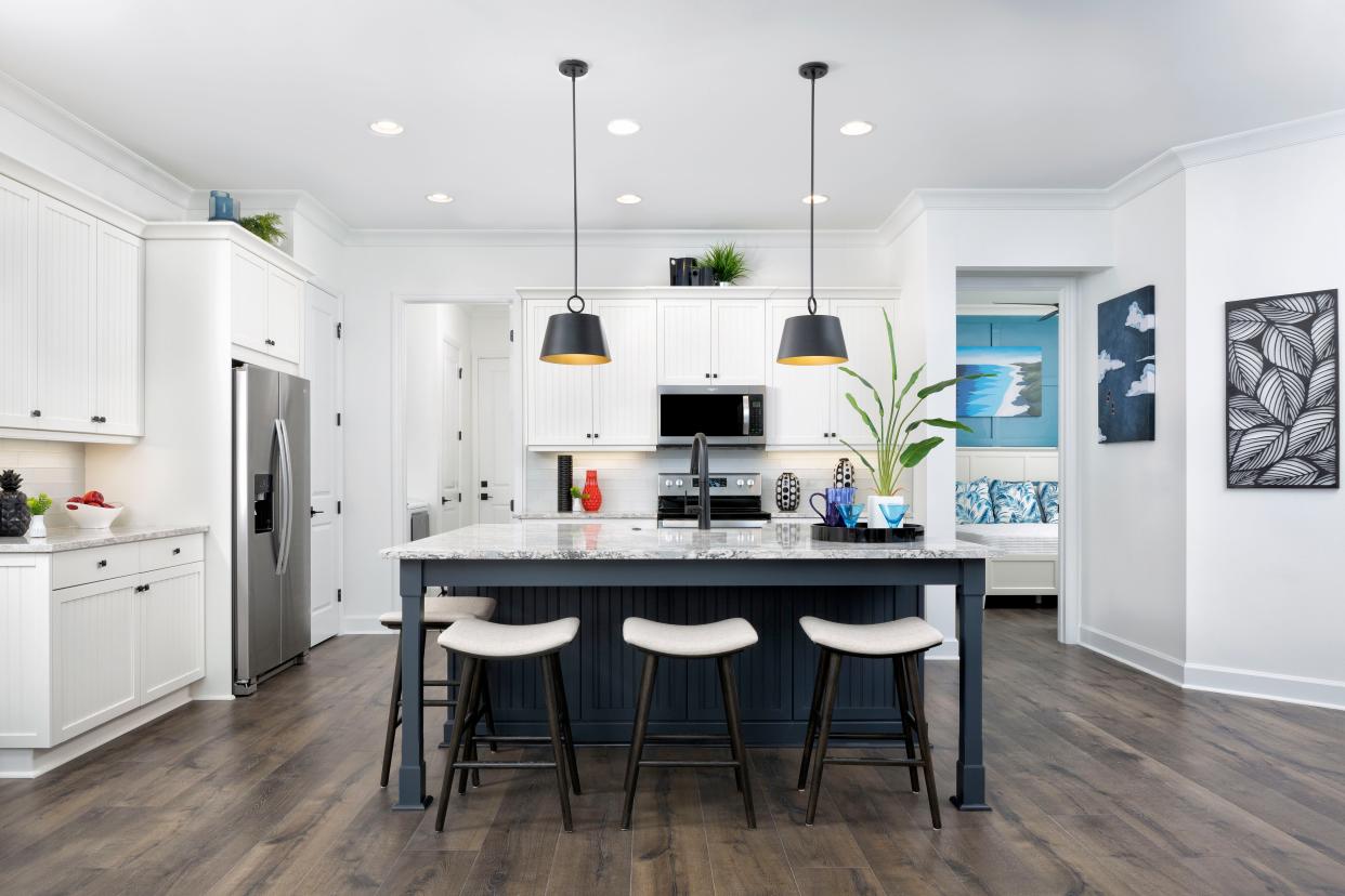 The Coastal Cottage Sanibel model kitchen features crisp white cabinetry, pantry and service/seating island.