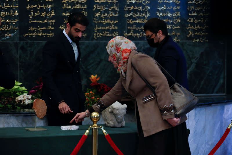 Officials look at The Gilgamesh Dream Tablet, stolen from Iraq in 1991, and other artefacts, at the Ministry of Foreign Affairs in Baghdad