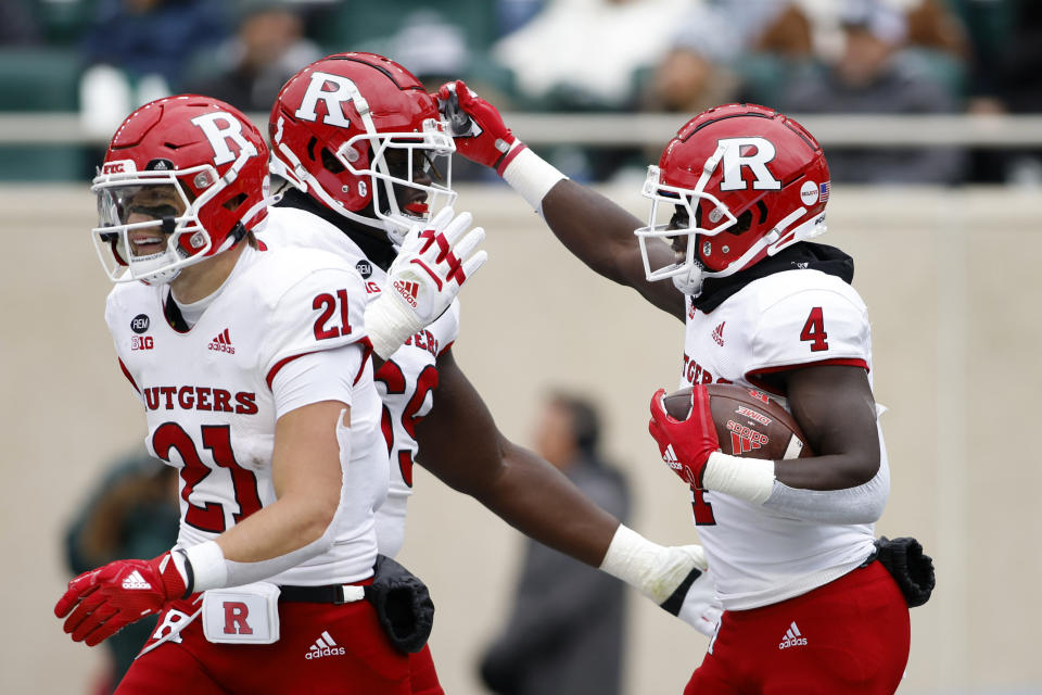 Rutgers' Aaron Young, right, celebrates his touchdown with Kwabena Asamoah, center, and Johnny Langan (21) against Michigan State during the first half of an NCAA college football game, Saturday, Nov. 12, 2022, in East Lansing, Mich. (AP Photo/Al Goldis)