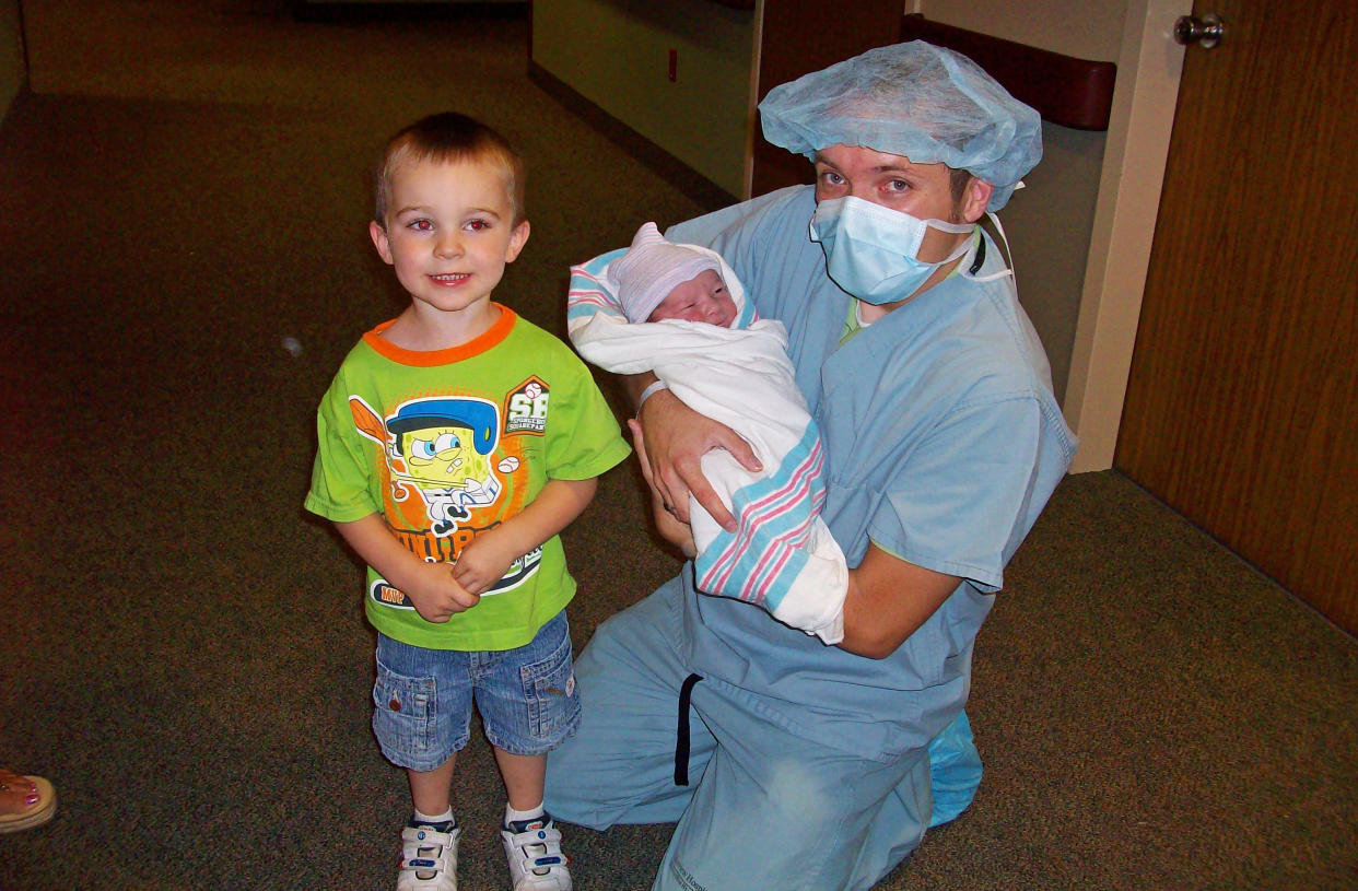 Vanner Johnson hold his newborn son, Tim, as his brother, Vanner, looks on. (Courtesy Vanner Johnson)