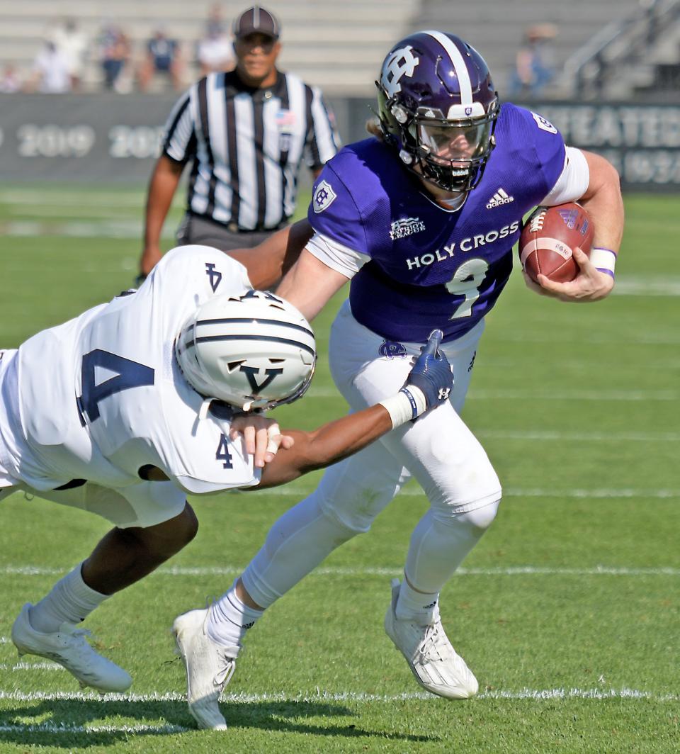 Holy Cross quarterback Matthew Sluka breaks away from the tackle attempt against Yale to score a touchdowns last September.