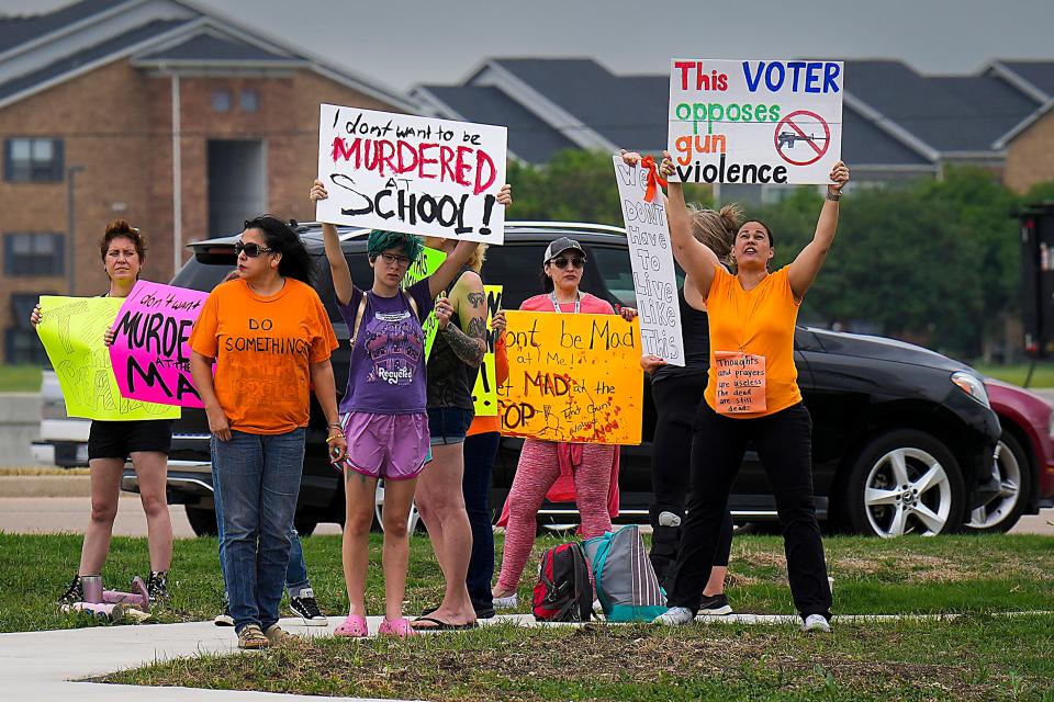 Protesters hold signs in support of gun control outside Cotton Wood Creek Church before a vigil a day after a mass shooting at a Texas outlet mall on May 7, 2023, in Allen, Texas.