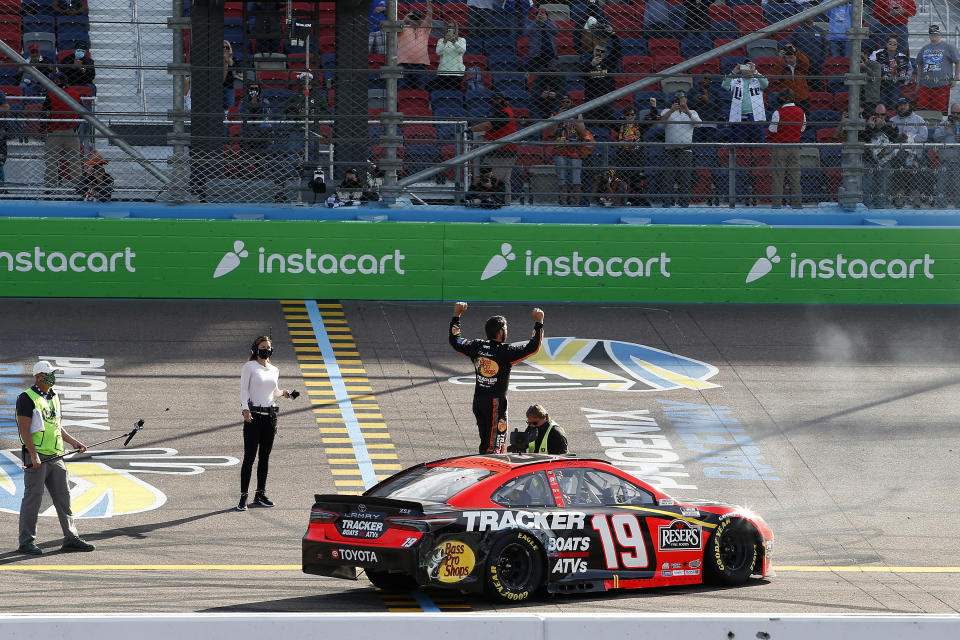 Martin Truex Jr. stands on his car as he celebrates after winning a NASCAR Cup Series auto race at Phoenix Raceway, Sunday, March 14, 2021, in Avondale, Ariz. (AP Photo/Ralph Freso)