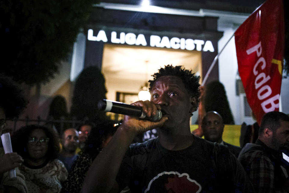A message that reads in Portuguese; "La Liga racist" is projected onto the Spanish Consulate, as people gather outside to protest against racism suffered by Brazilian soccer star Vinicius Junior who plays for Spain's Real Madrid, outside the Spanish Consulate in Sao Paulo, Brazil, Tuesday, May 23, 2023. Vinicius, who is Black, has been subjected to repeated racist taunts since he arrived in Spain five years ago. (AP Photo/Tuane Fernandes)
