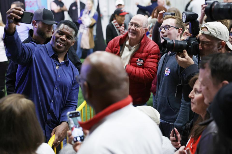 Georgia Republican Senate candidate Herschel Walker poses for selfies with supporters during a campaign rally on 5 December 2022 in Kennesaw, Georgia (Getty Images)