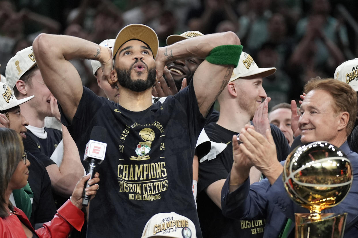 Boston Celtics forward Jayson Tatum, left, celebrates next to Celtics co-owner Stephen Pagliuca, right, near the Larry O'Brien Championship Trophy after the Celtics won the NBA championship with a Game 5 victory over the Dallas Mavericks on Monday, June 17, 2024, in Boston. (AP Photo/Charles Krupa)